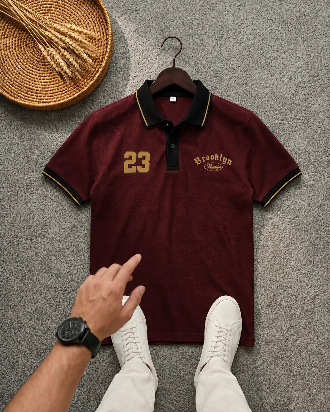 Maroon polo t-shirt with gold 'Brooklyn 23' embroidery on a grey background.