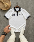 White Brooklyn polo t-shirt with number 23 and black collar on a grey background